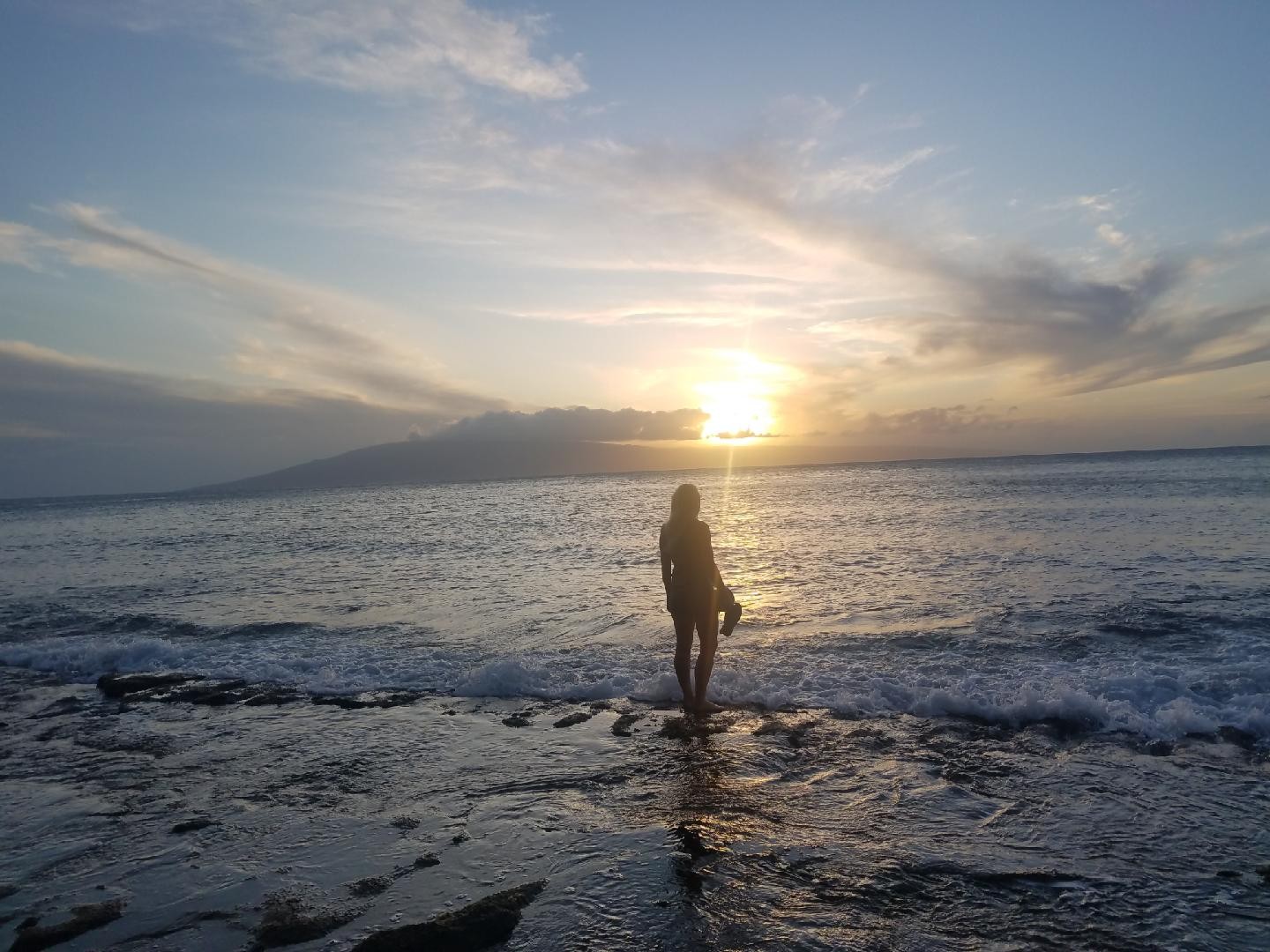 Jessica standing at the ocean shore at sunset, reflecting on her journey